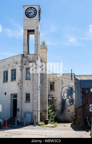 Ein banksy Wandmalerei, "Das Mädchen mit dem durchbohrten Trommelfell' auf ein Gebäude in Bristol, England Stockfoto