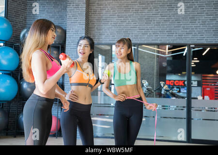 Asiatische junge fitness Frau ausführen Übung mit Übung - Maschine im Fitnessraum, Wellness Konzept. Stockfoto