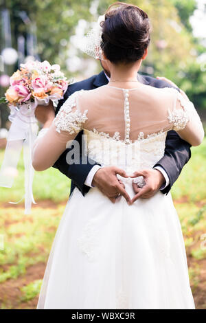 Braut und Bräutigam umarmen einander bei der Hochzeit Stockfoto