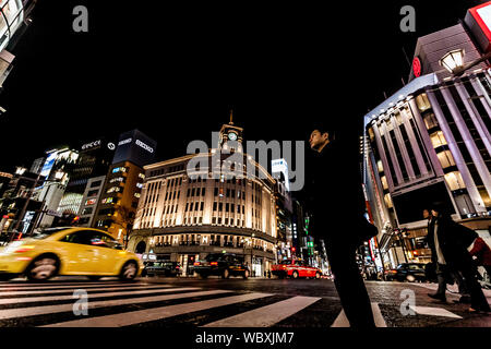 Tokyo, Japan - 14. Januar 2010: Fußgänger überqueren der Straße im Herzen von Ginza in Tokio. Ginza Kreuzung bei Nacht. Verschwommene Bewegung. Stockfoto