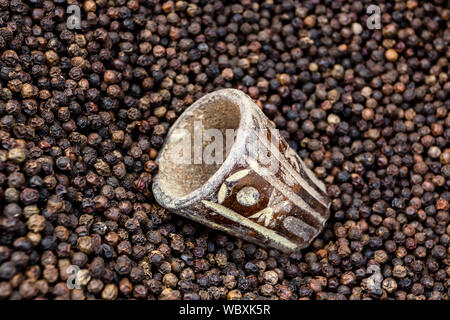 Schwarzer Pfeffer Körner in den asiatischen Markt. Schwarze pfefferkörner Nahaufnahme, Ansicht von oben Stockfoto