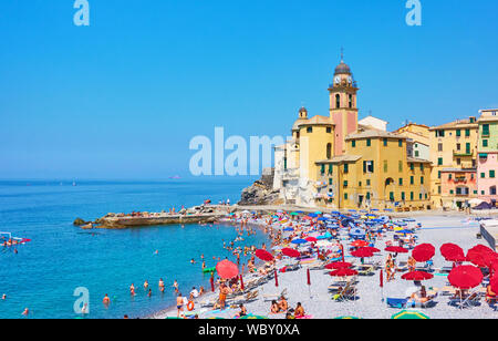 Camogli, Genua, Italien - Juli 3, 2019: Strand bei ruhenden Menschen in der Nähe der alten Kirche in Camogli an sonnigen Sommertagen Stockfoto