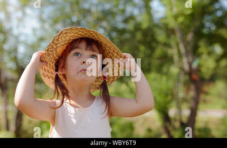 Überrascht kleines Mädchen im Stroh Hut oben zu schauen. Stockfoto