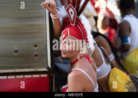 Performerin gekleidet in bunten Federn am Notting Hill Carnival, größte Karneval in Europa. Stockfoto