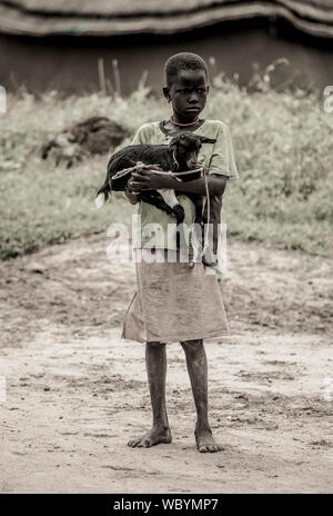 BOR, SOUTH SUDAN - NOVEMBER 2, 2013: Ein unbekanntes Mädchen hält ihre Ziege in der Stadt Bor, South Sudan Stockfoto