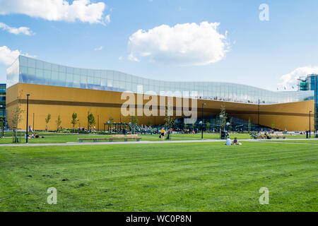 Helsinki, Finnland - Central Library Oodi - Die gesamte Fassade gesehen über frisch grünes Gras schneiden Stockfoto