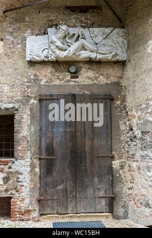 Skulpturen aus Stein relief Panels über eine alte hölzerne Tür im Innenhof des Teatro Olimpico, Vicenza, Venetien, Italien Stockfoto