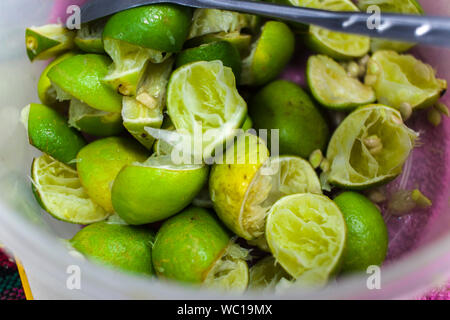 HSqueeze die Zitronenschale, grüne Zitrone in Plastikbecher. Igh resolution Image Gallery. Stockfoto