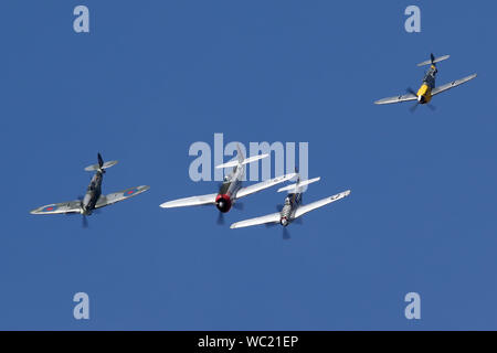Der "Historischen Fighters' Team von 4 Weltkrieg zwei Kämpfer, P-51, P-47, Spitfire und Buchon in Formation overhead Wattisham Flugplatz. Stockfoto