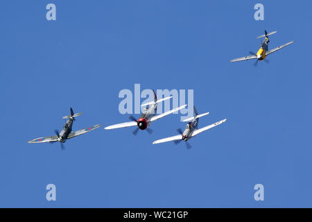 Der "Historischen Fighters' Team von 4 Weltkrieg zwei Kämpfer, P-51, P-47, Spitfire und Buchon in Formation overhead Wattisham Flugplatz. Stockfoto