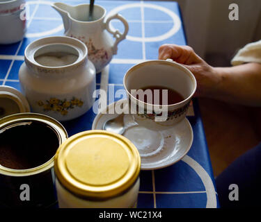 Frau trinkt Tee oder Kaffee am Tisch sitzen, innen close-up Stockfoto
