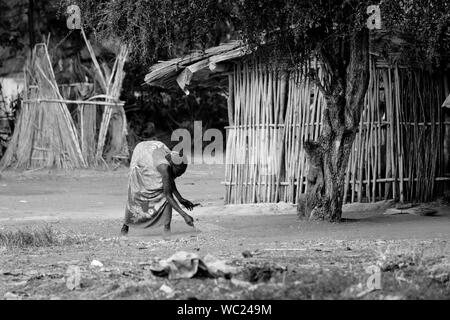 TORIT, SOUTH SUDAN - 21. FEBRUAR 2013: Nicht identifizierte Frau reinigt die Gegend rund um Ihr Haus im Süden des Sudan Stockfoto