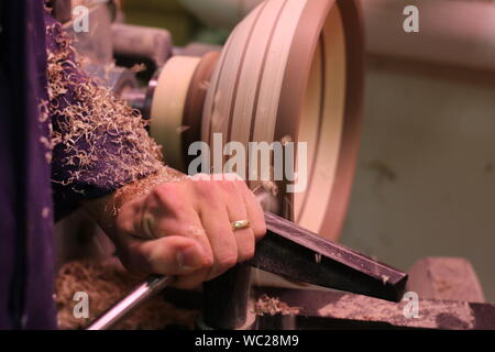 Schreiner bei der Arbeit, Holz - eine Schüssel auf der Drehmaschine. Stockfoto