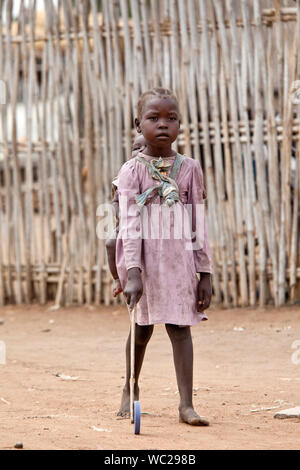 TORIT, SOUTH SUDAN - 21. FEBRUAR 2013: Unbekannter kleines Mädchen trägt ihre Schwester auf dem Rücken, während sie im Süden des Sudan spielt. Stockfoto