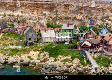 Blick auf den berühmten Dorf von Popeye mit bunten Holzhäusern und den Golf von Malta. Stockfoto