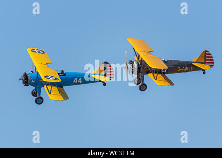 Boeing Stearman Doppeldeckerpaar fliegt auf der Children in Need Little Gransden Air & Car Show, Großbritannien. Vintage-Doppeldecker Stockfoto