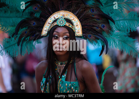 Performerin gekleidet in pfauenfedern an der Notting Hill Carnival, London, UK, größte Karneval in Europa. Stockfoto