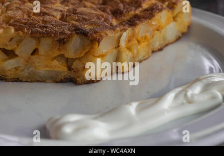 Spanisches Omelette mit Mayonnaise, auf einer weißen Platte Stockfoto
