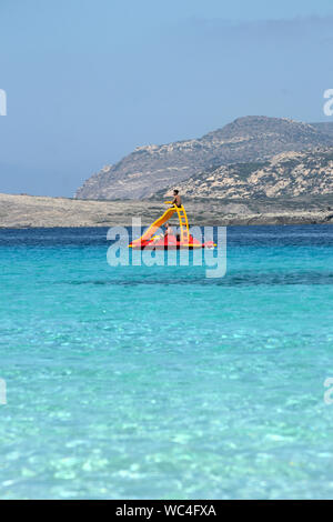 Stintino, Sardinien, Italien, August 08, 2019, einige Touristen fahren mit dem Tretboot auf dem schönen türkisblauen Wasser der sardischen Meer in der Nähe von Stintino mit t Stockfoto