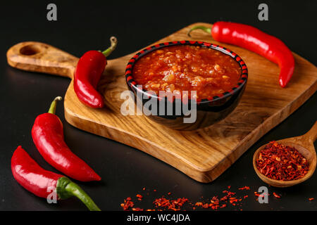 Die traditionellen maghrebinischen Hot Chili Sauce paste Harissa auf dunklem Hintergrund, Tunesien und arabische Küche, horizontale Ausrichtung Stockfoto