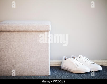 Paar neue stilvolle weißen Turnschuhen auf dem Boden zu Hause. Stockfoto