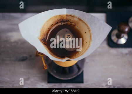 Brewign dritte Welle Kaffee mit Chemex Glas und Tropf Wasserkocher für den reinen Geschmack in gutem Design auf Holztisch Stockfoto