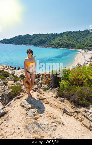 Schöne junge Frau auf exotische Platanitsi Strand in Sarti, Sithonia, Griechenland mit kristallklarem Wasser und spektakuläre Formen der Felsen Stockfoto