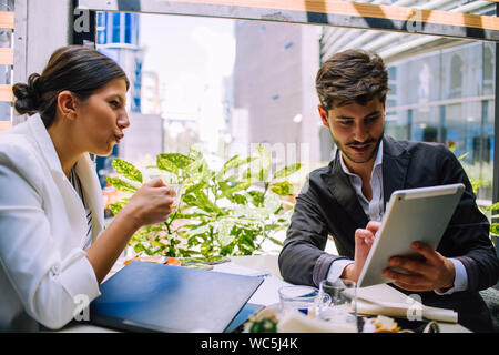 Zwei Geschäftspartnern im Cafe zu sitzen und zu diskutieren, gemeinsame Projekt auf pc Tablet Stockfoto