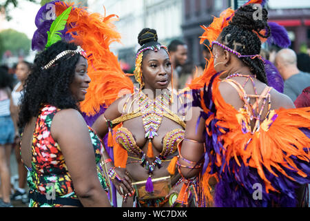 Tänzerinnen im Gespräch auf der Straße während der Notting Hill Carnival, Europas größtes Festival. Stockfoto