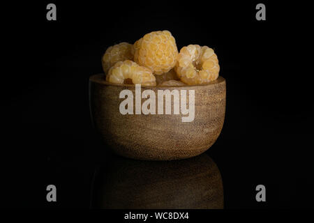 Menge ganze frische goldene Himbeere hymalayan in Houten auf schwarzem Glas isoliert Stockfoto