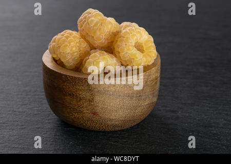 Menge ganze frische goldene Himbeere hymalayan in Houten auf grauem Stein Stockfoto