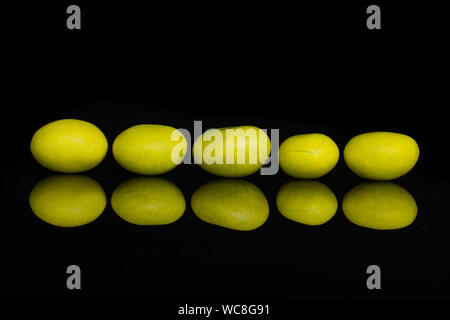 Gruppe von fünf ganz gelb gezuckerte Mutter Dragiermaschinen u.a. auf schwarzem Glas isoliert Stockfoto