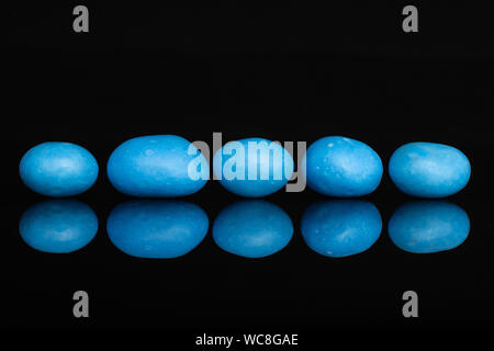 Gruppe von fünf ganze Blau gezuckerte Mutter Dragiermaschinen u.a. auf schwarzem Glas isoliert Stockfoto