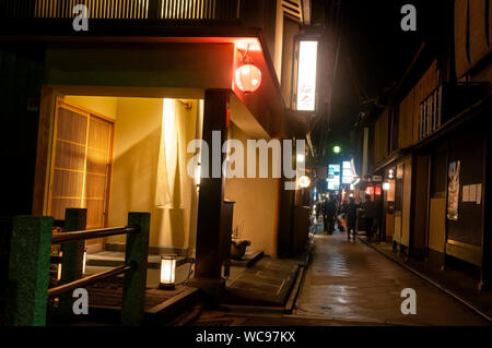 Noren-Vorhänge und Laternen beleuchten den Weg auf einer Fußgängerzone in Kyoto, Japan. Stockfoto