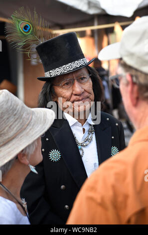 Darrell Jumbo, einem Navajo Schmuck Künstler, Gespräche mit Besuchern an den jährlichen Santa Fe indischen Markt in Santa Fe, New Mexico. Stockfoto