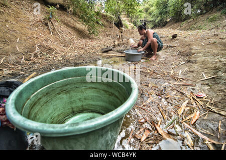 Bekasi, Indonesien. 27 Aug, 2019. Ein Bewohner sammelt das Wasser aus einem Einzugsgebiet gut am cihoe Fluss. Die Meteorologie, Klimatologie und Geophysik Agentur hat davor gewarnt, dass die trockene Jahreszeit kann trockener und intensiver als im letzten Jahr aufgrund der El Niño-Phänomen. Die Agentur klassifiziert, West Java, Central Java, die meisten Teile von Ost Java, Jakarta, Bali und Nusa Tenggara, da der Bereich der meisten anfällig für extreme Dürre, oder mehr als 60 Tage ohne Regen. Credit: SOPA Images Limited/Alamy leben Nachrichten Stockfoto