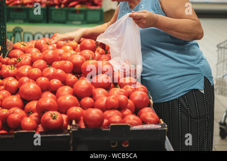 Eine Frau mit biologisch abbaubaren Kunststoff essen Beutel Obst und Gemüse aus dem Supermarkt zu kaufen Stockfoto