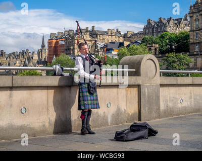 Nicht identifizierte Dudelsackpfeifer spielen Musik mit Dudelsack entlang der Damm am 26. Juli 2017 in Edinburgh, Schottland. Es gibt viele bagpipers Straßenmusik und Unterhaltung Stockfoto