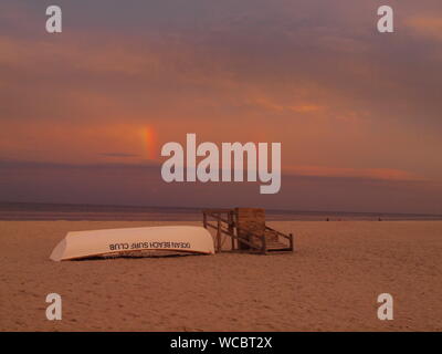 Regenbogen über dem Atlantik von Ocean Beach, New Jersey mit Rettungsschwimmer stehen und Rettungsboot im Vordergrund. Stockfoto