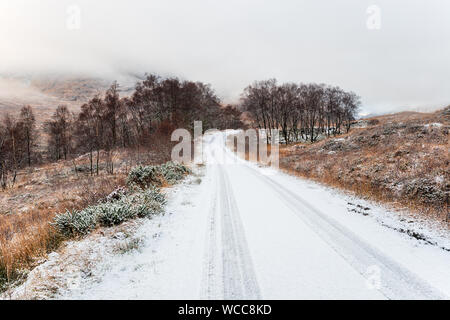 Eine verschneite Straße bei führenden durch Glen Etive in den Highlands von Schottland Stockfoto