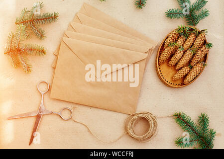 Weihnachten Geschenke und Briefe handgefertigt, und alles notwendige für Sie. Umschläge aus Kraftpapier, Schere, Fichte Kegel und Jute Schnur. Der Blick von Stockfoto