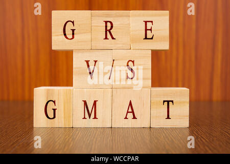 Konzept der GRE vs GMAT-Prüfung Unterschiede in den Holzklotz Buchstaben auf dem Tisch. Stockfoto