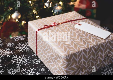 Selektive Nahaufnahme einer weihnachtlich dekorierten Geschenkbox mit Ein leeres Tag als Leerzeichen für Ihren Text Stockfoto
