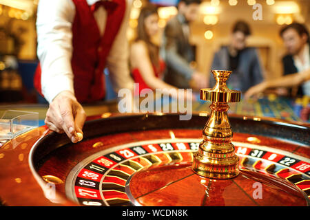 Der Croupier hält eine Kugel in einem Casino in seiner Hand. Stockfoto