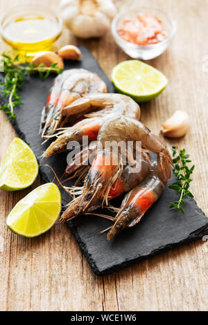 Frische rohe Garnelen und Gewürzen auf hölzernen Tisch Stockfoto