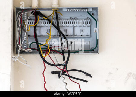 Öffnen Sie eine leere Strom Sicherungskasten mit Kabel an der weißen Wand. Elektrischer Schaltkasten mit leeren Sicherungskästen in einem verlassenen Gebäude. Beschädigte Circ. Stockfoto