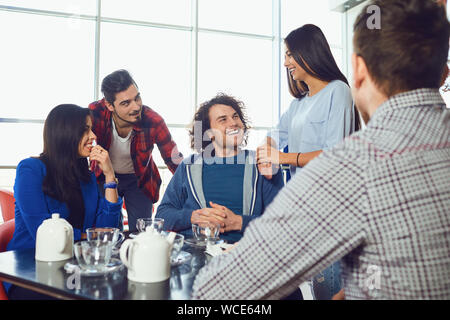 Lustige Freunde reden und lachen in einem Café. Stockfoto