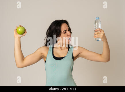 Happy fitness lächelnde Frau mit einem Apfel und Wasserflasche Gefühl stark und gesund. In gesunden Lebensstil, Training und Ernährung. Portrai Stockfoto