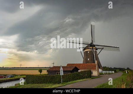 Holländische Windmühle mit einem herannahenden Gewitter Stockfoto