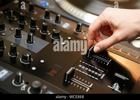 Weibliche DJ spielt Musik mit professionellen Audiogeräten auf der Bühne im Night Club. Hip Hop disc jockey Mädchen mischt musikalische Titel mit top Sound Mixer Fensterbereich Stockfoto